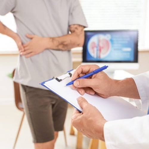 Mature,Urologist,Writing,On,Clipboard,In,Clinic,,Closeup